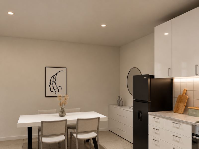 Cozinha da fração F, com mesa de refeições e armários brancos