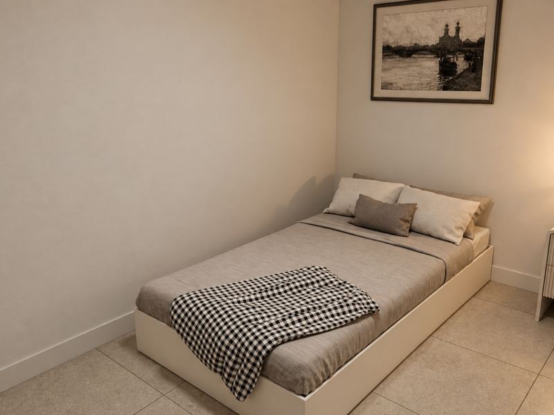 Quarto da fração K, com cama de solteiro e quadro na parede